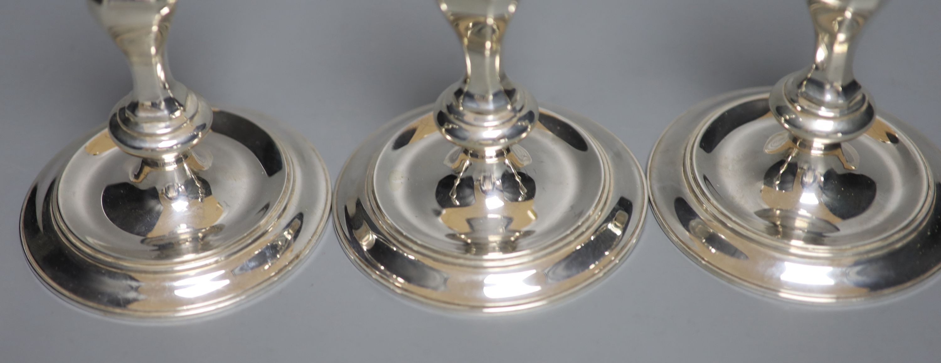 A modern set of three 18th century style cast silver candlesticks, J.B. Chatterley & Sons, Birmingham, 1987, 14.5cm, 24oz.